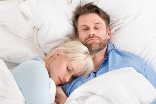 Couple Sleeping Together In Bed