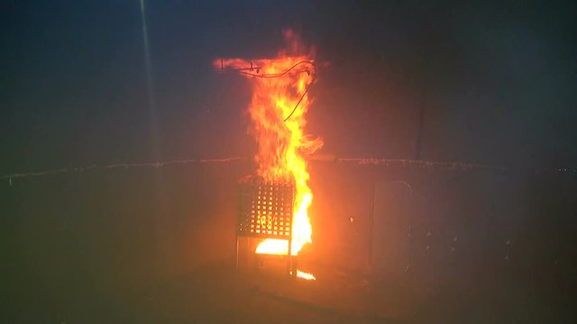 Bright and dangerous fire in the hold. Fire tests in a closed room. Flames of fire and black smoke. Strong fire high danger level. Black smoke from a fire. 