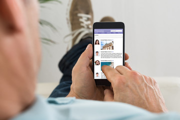 Man Surfing On Social Networking Site Using Cellphone
