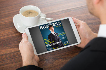 Businessman Reading Online Magazine On Digital Tablet