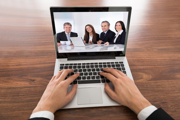 Fototapeta na wymiar Close-up Of Businessman Video Conferencing On Laptop