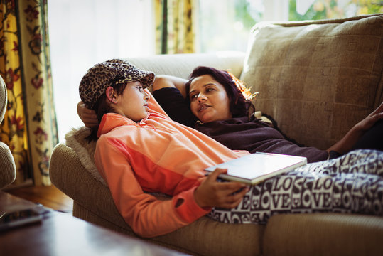Mother and daughter relaxing on sofa