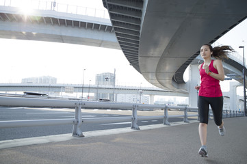 Women are jogging under the highway