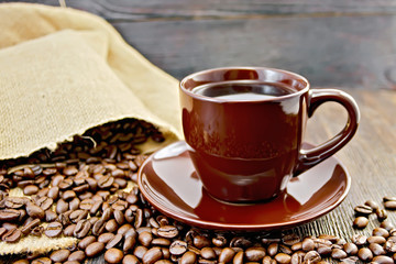 Coffee in brown cup with bag on board