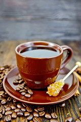 Coffee in brown cup with sugar and grain on board