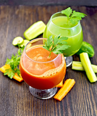 Juice carrot and cucumber in wineglass on board