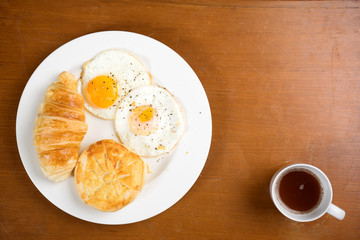 breakfast biscuit croissant coffee on teak
