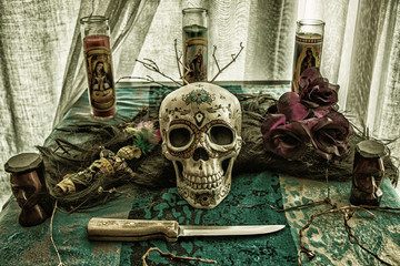 Voodoo Skull Ritual Evil. Voodoo related objects on a table including a skull, a knife and candles. - obrazy, fototapety, plakaty