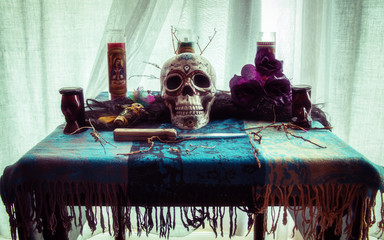 Voodoo Skull Ritual. Voodoo related objects on a table including a skull, a knife and candles.