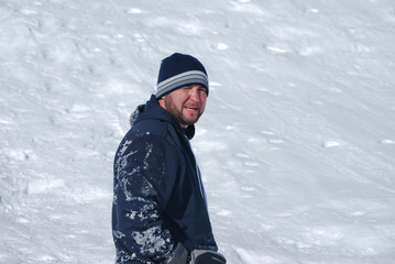 Fototapeta na wymiar Man in sweatshirt looking back at camera in the snow