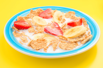 bowl of cereal with milk and bananas strawberries