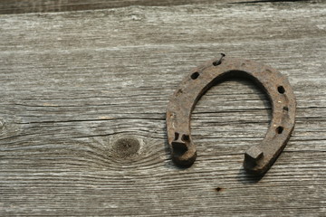 Rusty horseshoes on a wooden background - rustic scene in a country style. Old iron Horseshoe -...