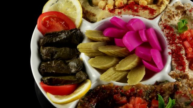 Plate of assorted appetizer (Hummus, Baba Ganouj, Mutabal, Dolma vegetable, Syrian pickled cucumbers, Pickled turnips), loop