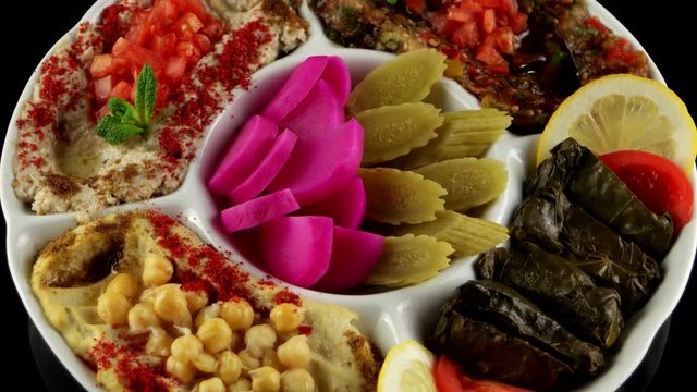 Plate of assorted Middle East appetizer with Hummus, Baba Ganouj, Mutabal, Dolma vegetable and Syrian pickled cucumbers, loop