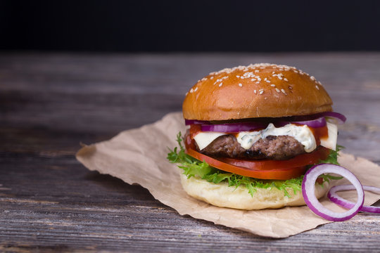 Juicy burger on wooden background
