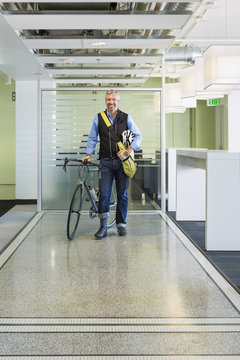 Caucasian businessman with bicycle in office