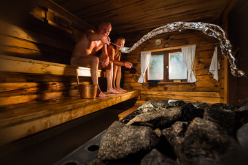 Middle aged couple in traditional wooden Finnish sauna