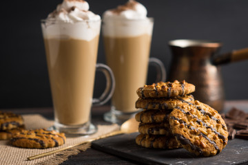 Glass of coffee with cookies on wooden background