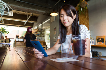 Woman enjjoy her coffee and look at the cellphone