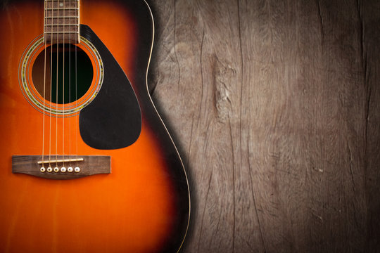 Acoustic guitar resting against a blank grunge background with c