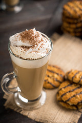 Glass of coffee with cookies on wooden background. Shallow depth of field.