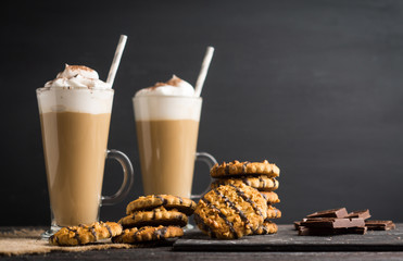 Glass of coffee with cookies on wooden background