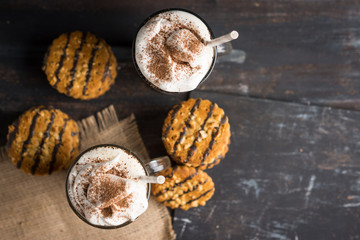 Glass of coffee with cookies on wooden background. Shallow depth of field.