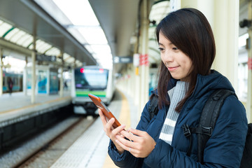 Woman use of mobile phone in trains station