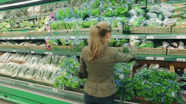 Woman buy fresh parsley in modern supermarket
