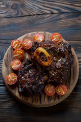 Osso buco with baked tomatoes in a rustic wooden setting