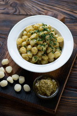 Boiled potato gnocchi with basil pesto and parsley, close-up