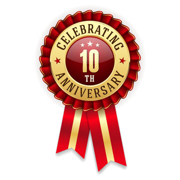 Gold 10th anniversary badge, rosette with red ribbon on white background