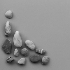 smooth river stone on gray background. zen like concepts. square photo. Free space for text. Copy space. black and white image