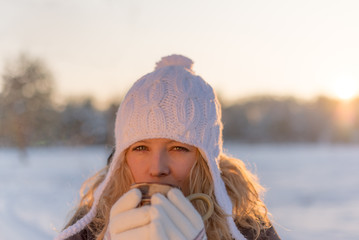 Girl sipping hot coffie in a cold winter day