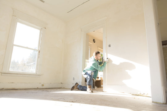 Mixed race carpenter working on doorway
