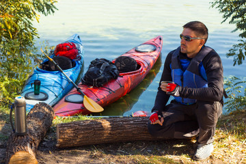 The man is kayaking on the river. 
