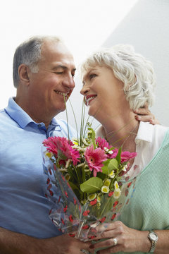 Older couple holding bouquet of flowers