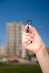 Child hand holding an old key on a string