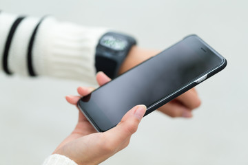 Woman use of cellphone and connecting smartwatch