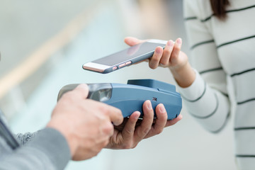 Woman using cellphone pay by NFC