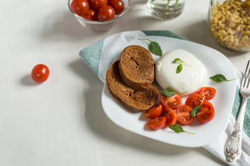 Plate of Caprese Salad with Mozzarella Cheese, Tomatoes, Basil a