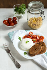 Plate of Caprese Salad with Mozzarella Cheese, Tomatoes, Basil a