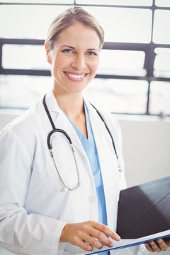 Portrait of female doctor holding medical report
