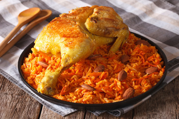 Arabic food: kabsa with chicken and almonds close-up on a plate. Horizontal

