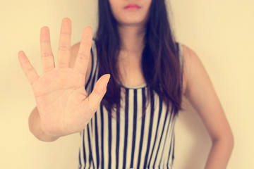 Young woman showing her denial with NO on her hand, vintage filtered image.