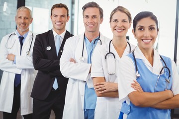 Happy medical team standing with arms crossed