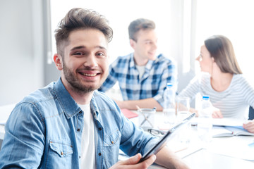 Cheerful man holding tablet