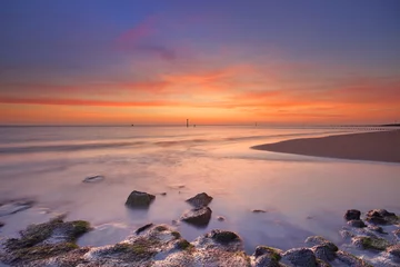 Gordijnen Beach with rocks at sunset in Zeeland, The Netherlands © sara_winter