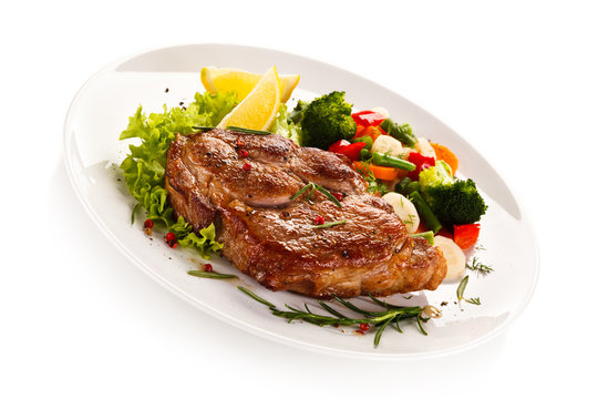 Grilled steak and vegetables on white background
