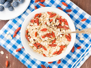Bowl with oats and goji berries for breakfast to be eaten with smoothie or yogurt